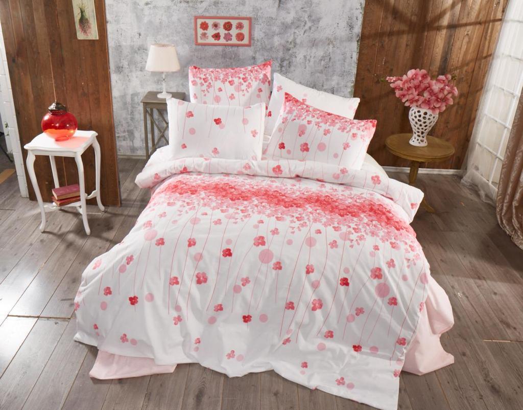 Bed linen set with pink flowers and fine stripes on a bed