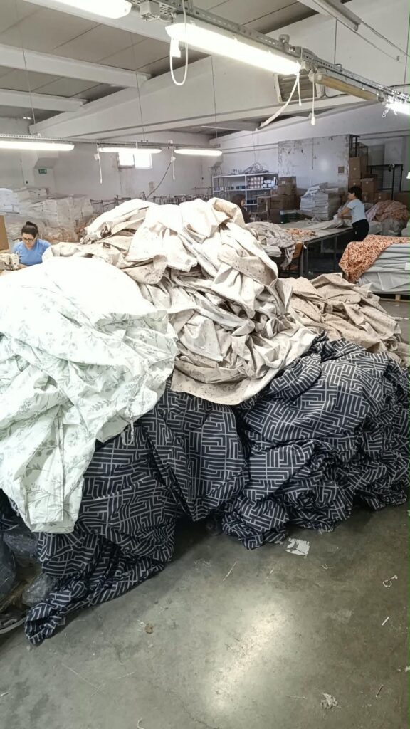 Desenli kumaşların işlendiği dikiş at&ouml;lyesi ve &ccedil;alışma masaları