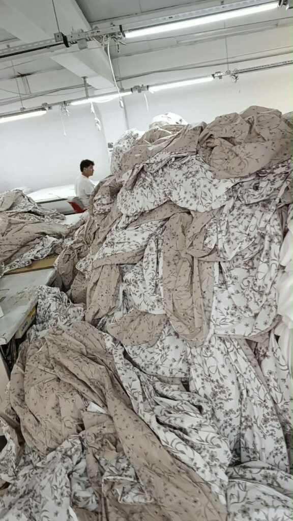 &Uuml;retim alanında &ccedil;alışma masaları &uuml;zerinde birikmiş &ccedil;i&ccedil;ek desenli kumaşlar