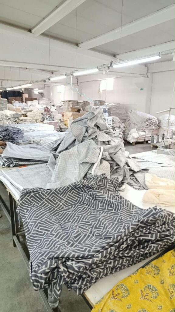 Geometrik desenli kumaşların bulunduğu dikim masaları ve at&ouml;lye alanı