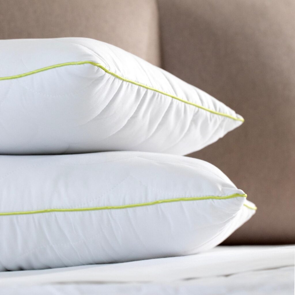 Piping and corner stitching details of white quilted pillows