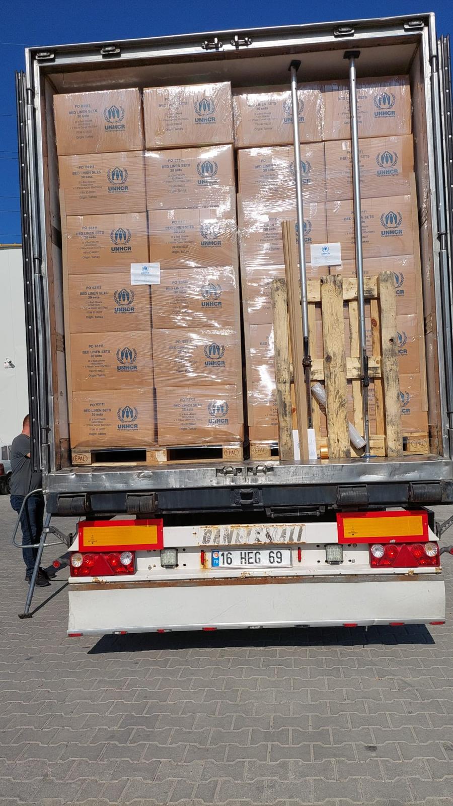 Scatole con scritta UNHCR impilate e fissate nel cassone di un camion